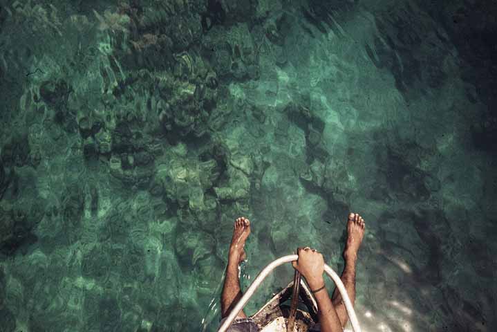 personnes les pieds dans l'eau depuis un bateau